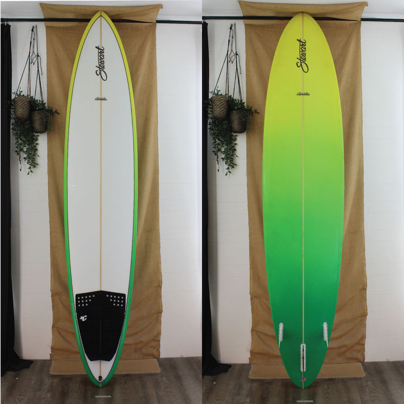 Deck and bottom view of a used Stewart Clydesdale Longboard with a white deck and and a yellow fade into green on the rails and bottom of board