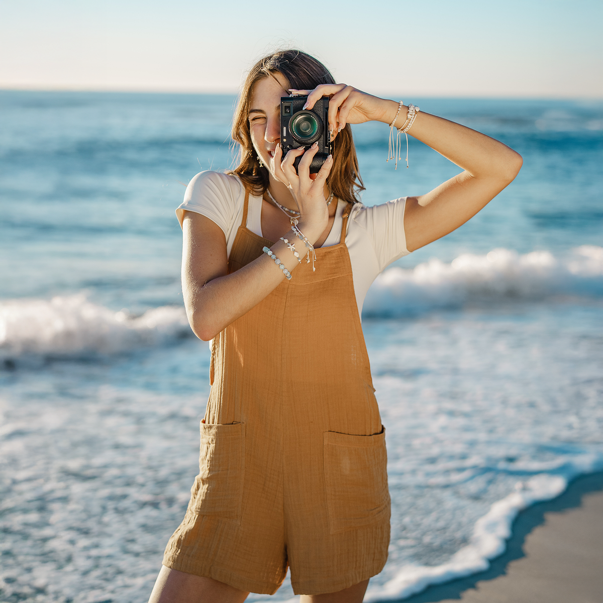 Person taking a photo on a beach with a camera