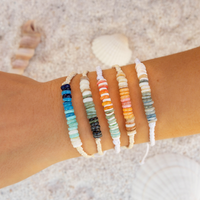 Set of beaded bracelets on a wrist with a beach background