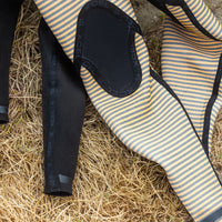 Close-up of striped wetsuit on grass with XCEL branding
