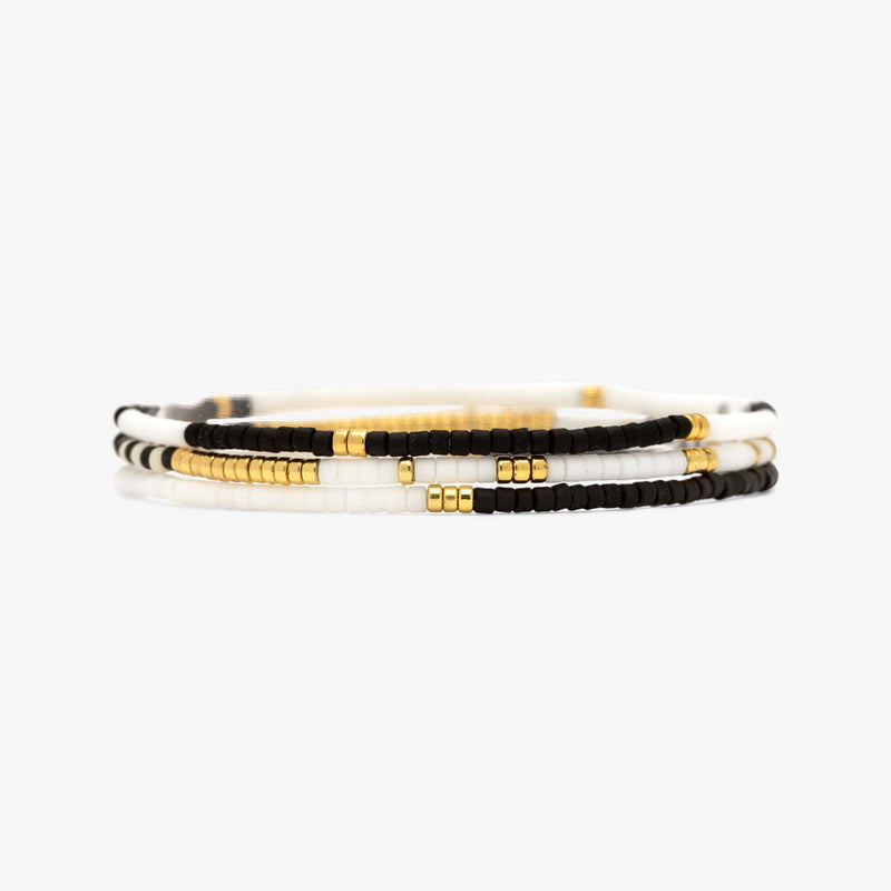 A set of three gold and multicolored seed bead stretch bracelets displayed on a white background.
