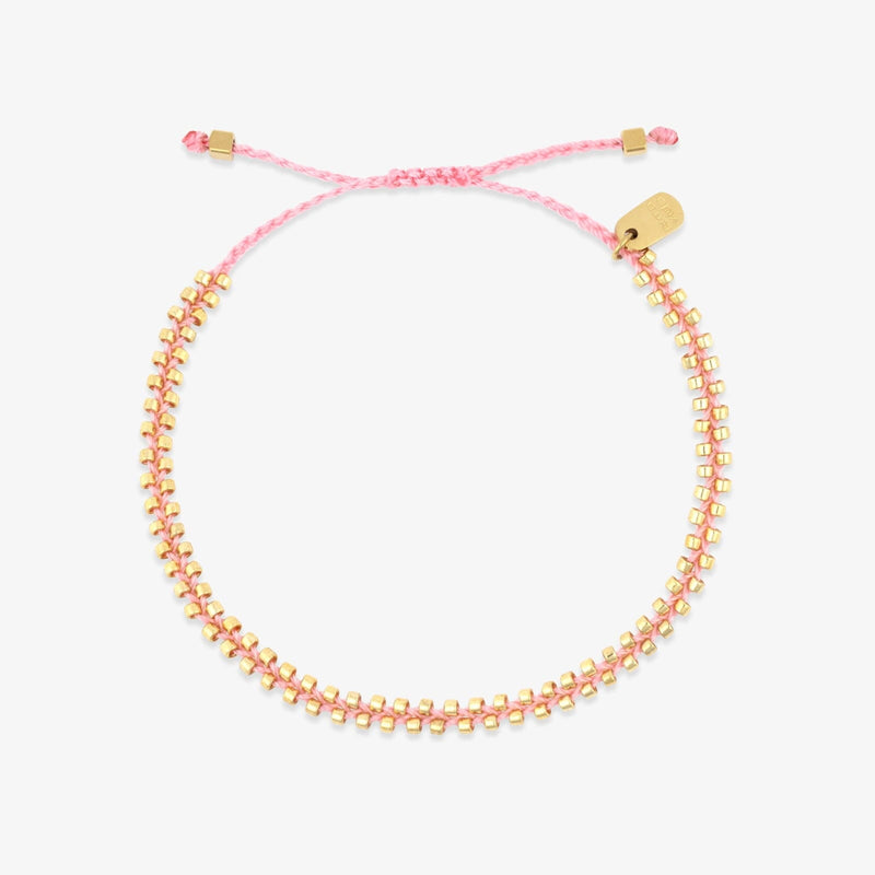 Pink and gold beaded bracelet on a white background