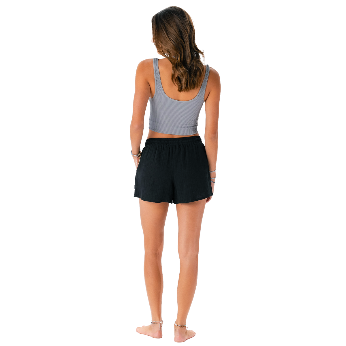 Woman wearing a gray tank top and black shorts on a white background