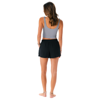 Woman wearing a gray tank top and black shorts on a white background