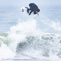 Person surfing on a wave with a clear sky background