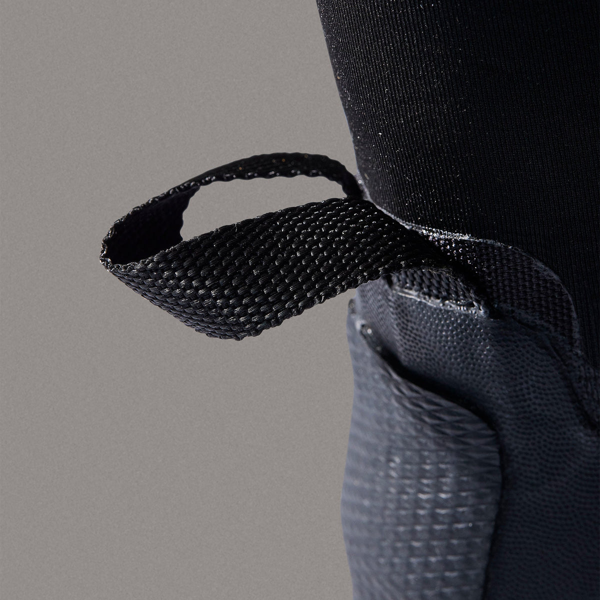 Close-up of a textured black strap on a gray background