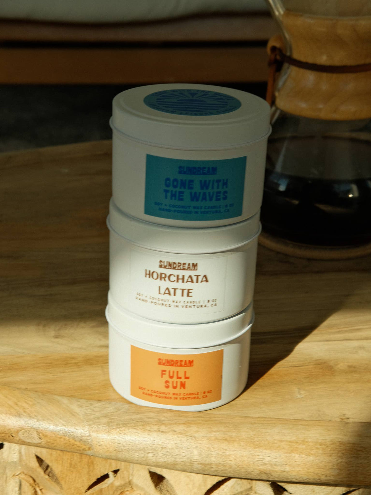 Three containers of 'Sunbeam' products stacked on a wooden surface.