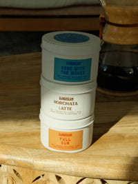 Three containers of 'Sunbeam' products stacked on a wooden surface.