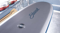 bottom view of the nose of the Stewart HydroCush Redline 11 soft top longboard surfboard with beveled rails and grey bottom with blue logos