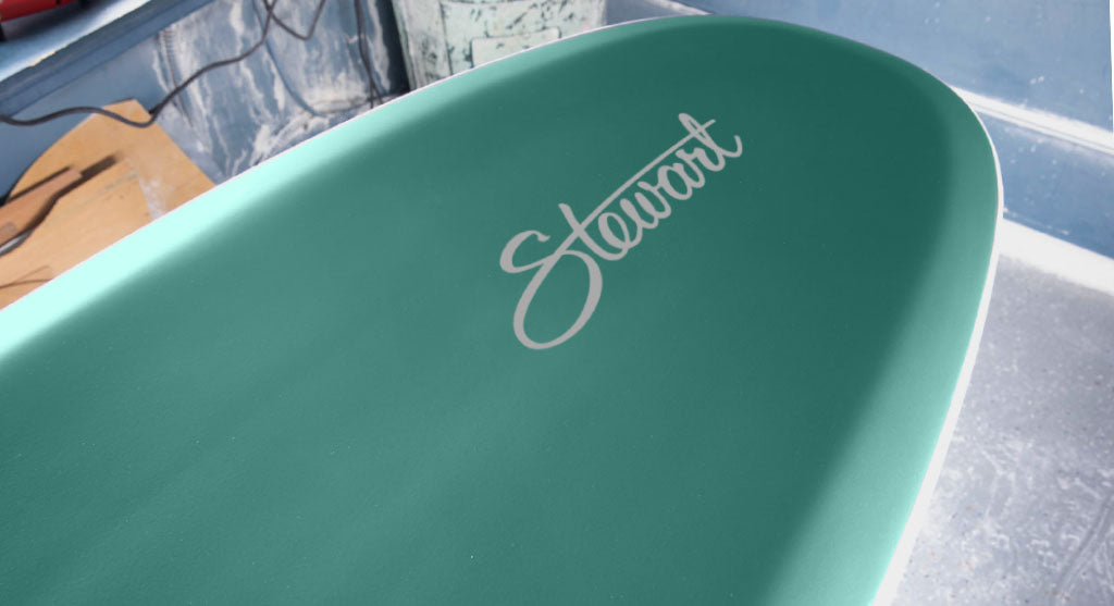 detail bottom view of the nose of the Stewart HydroCush Redline 11 soft top longboard surfboard with beveled rails and emerald green bottom