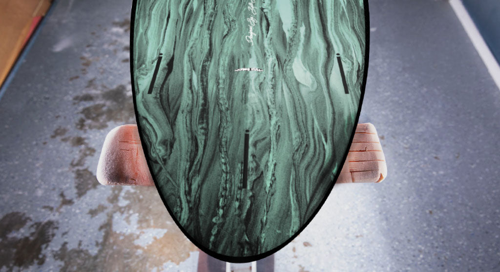 detail view of the tail and fin boxes on the Stewart HydroCush Wild Bill soft top mid length surfboard with sage and black swirl bottom