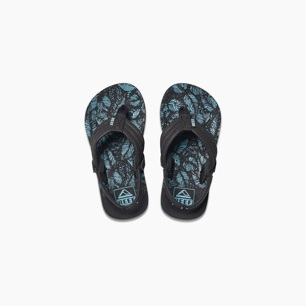 A pair of Reef kids' Ahi sandals with black synthetic straps and a blue leaf pattern on a white background.