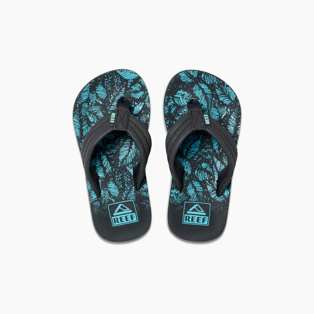 A pair of Reef kids' Ahi sandals with black synthetic straps and a blue leaf pattern on a white background.