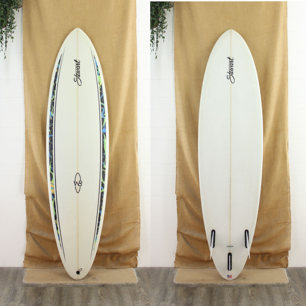 Deck and bottom view of a Stewart Wild Bill with a clear bottom and a clear deck with some green and blue artwork on the rails