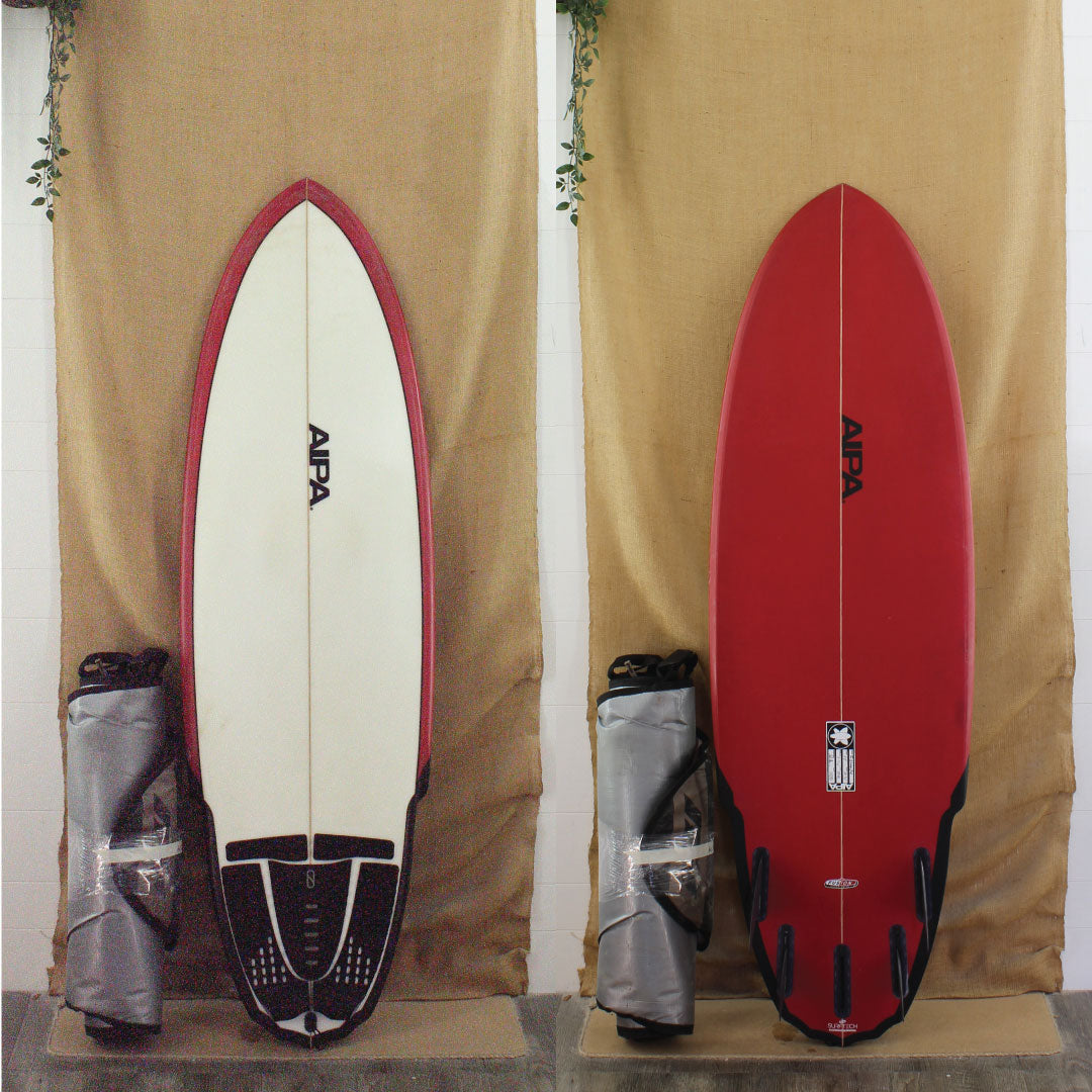 red surfboard with fins and board bag used