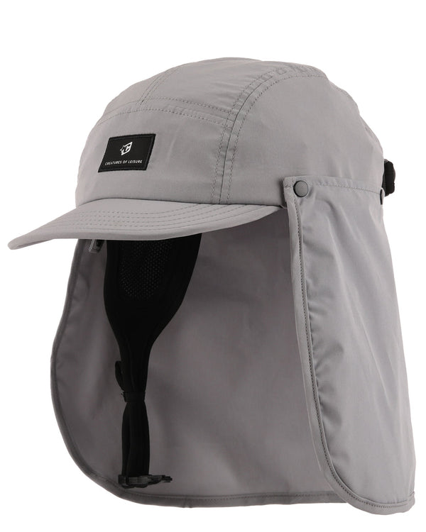 A light gray outdoor cap with an attached neck flap and chin strap, shown on a plain white background. A small black brand patch on the front 