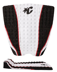 A black, white, and red surfboard tail pad shown from the back, featuring a textured grip pattern, a black stylized 'XC' logo, and a separate matching adhesive backing strip displayed below on a white background.