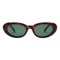Sunglasses with tortoiseshell frame and green lenses on a white background