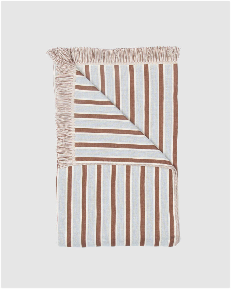 Striped blanket with brown and white stripes on a light gray background