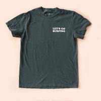 Dark gray t-shirt with 'LET'S GO SURFING' text on a beige background