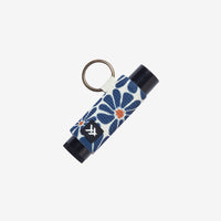 Keychain with floral design and black container on a white background