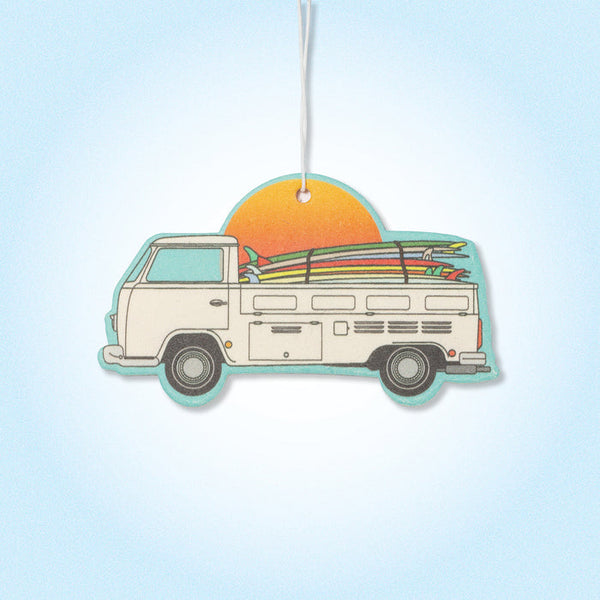 Car air freshener with a van and surfboards design on a light blue background