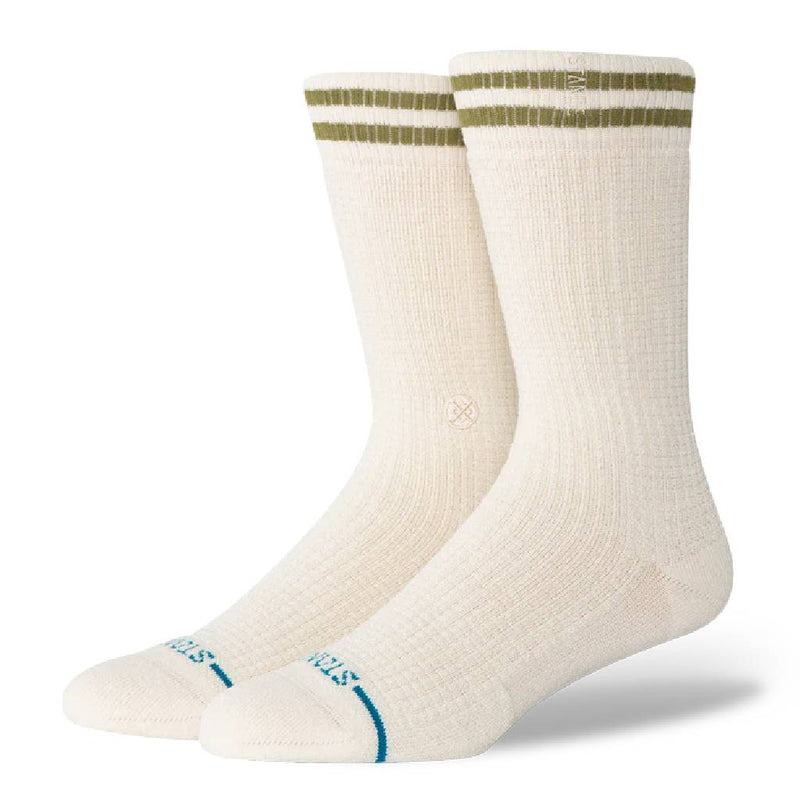Pair of cream socks with green and blue accents on a white background
