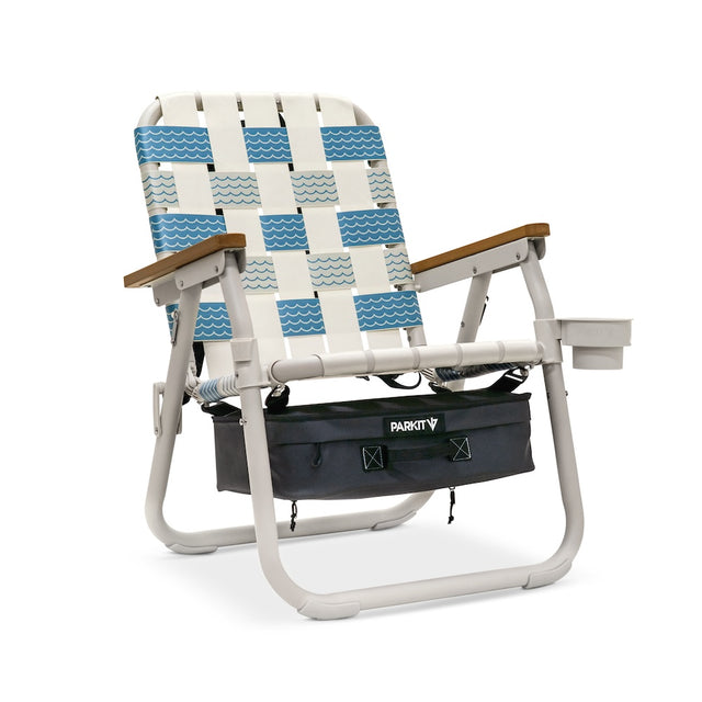 Beach chair with blue and white patterned backrest and wooden armrests on a white background