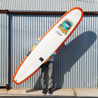 Photo of the deck of the surfboard against a metal wall