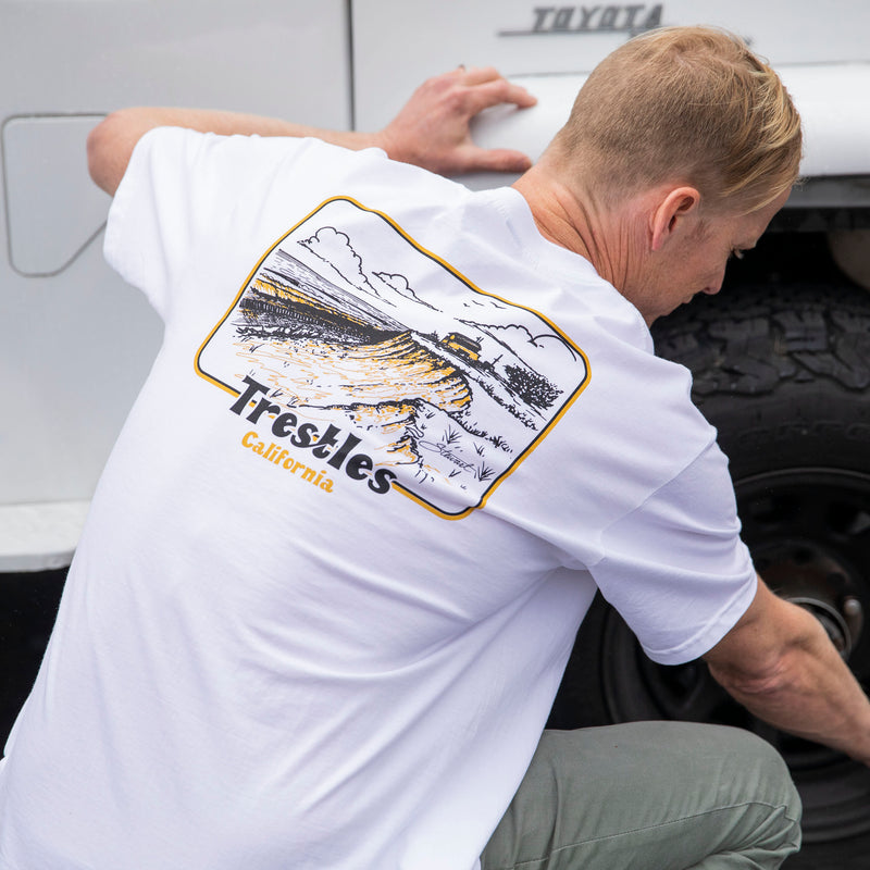 Guy wearing Stewart Trestles t-shirt while checking tire