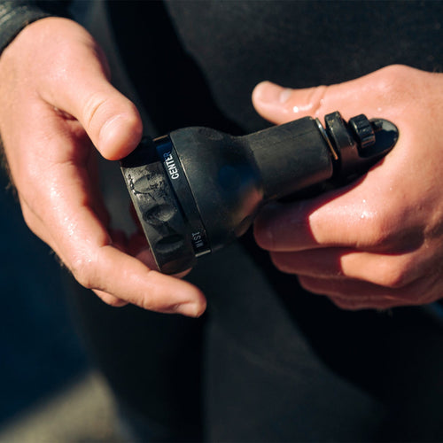 Close-up of hands holding a black flashlight with a brand logo.