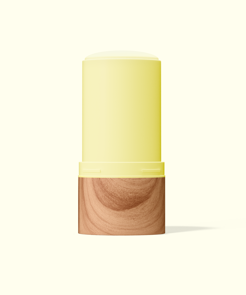 Two-toned cylindrical container with yellow top and wooden bottom on a white background