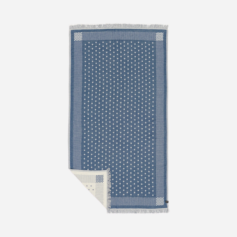 Blue and white patterned towel on a light gray background
