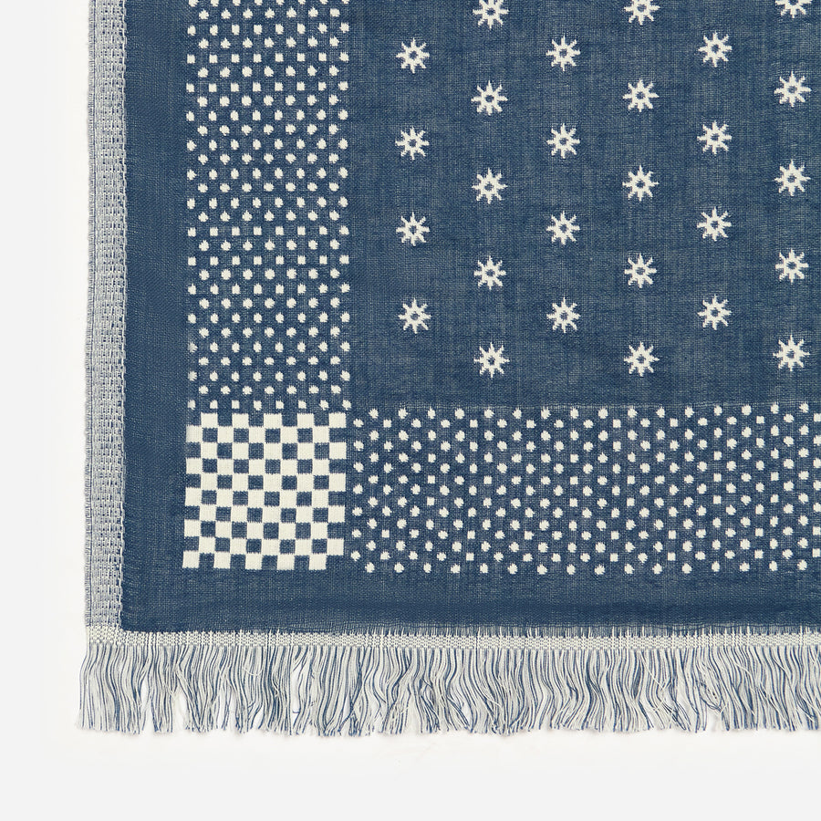 Blue and white patterned fabric with stars and dots on a white background
