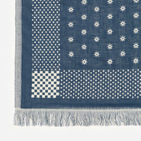 Blue and white patterned fabric with stars and dots on a white background