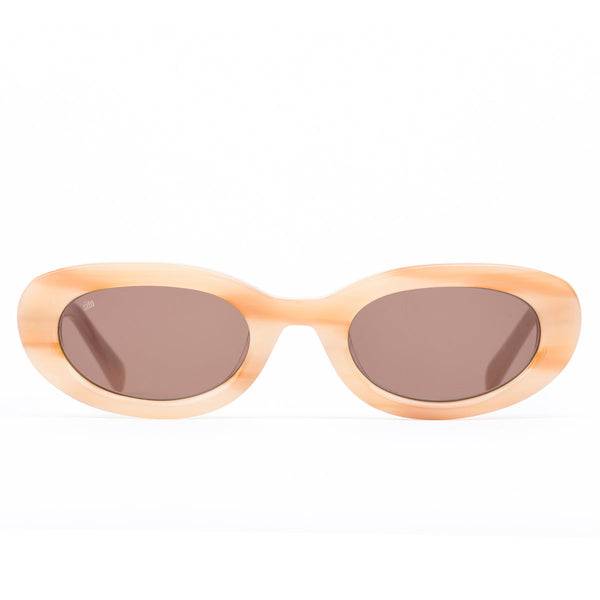 Oval sunglasses with a translucent peach-colored frame and brown tinted lenses, shown against a plain white background.