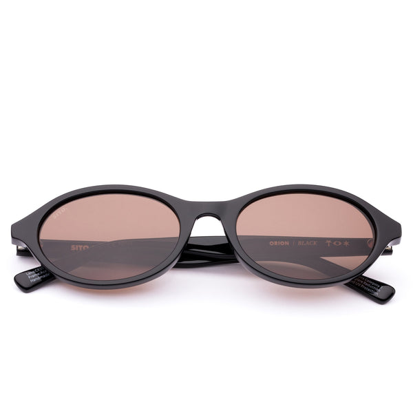 Black sunglasses with brown lenses on a white background