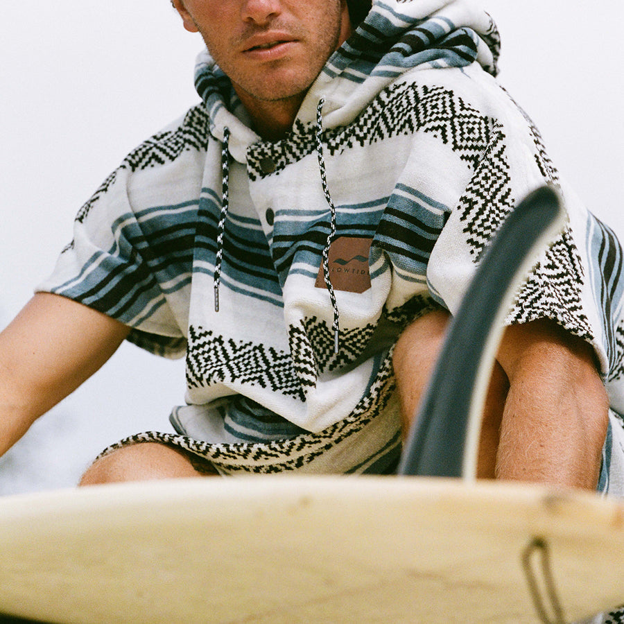 Person wearing a patterned shirt and scarf with a blurred background