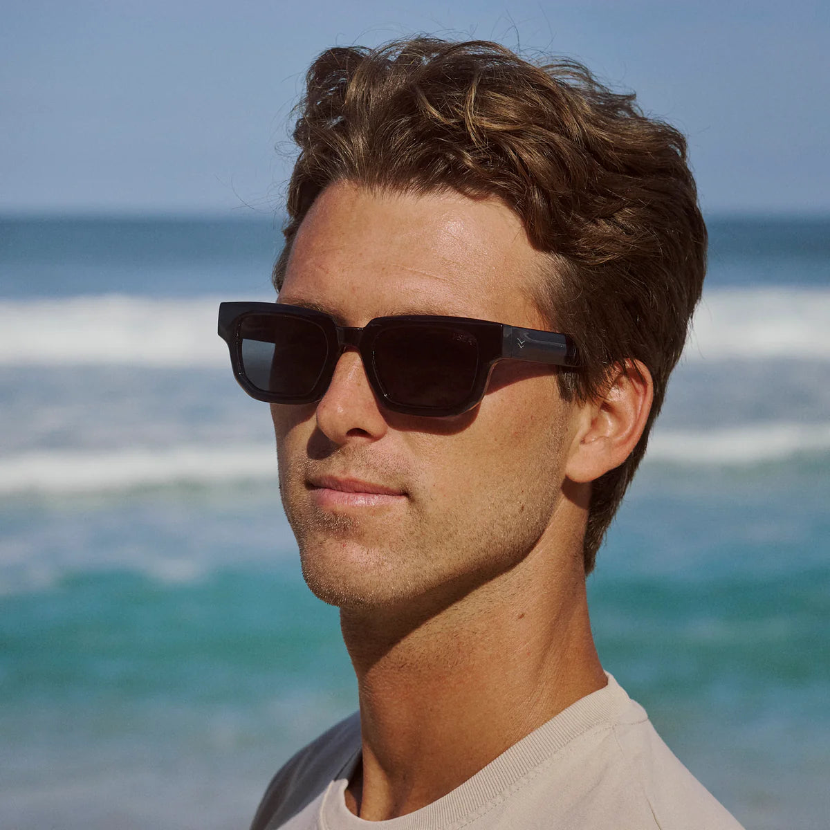 Man wearing sunglasses with a beach background