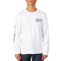 A man wearing a white long-sleeve t-shirt with blue graphic prints on the chest and sleeve, paired with dark pants, against a plain white background.