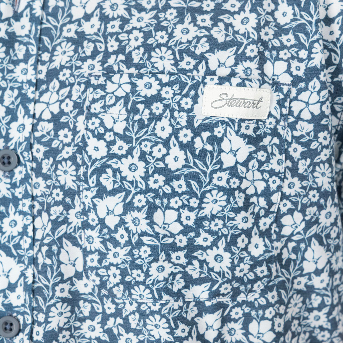 Close-up of a blue and white floral button-up shirt with a visible Stewart brand label on the chest pocket.