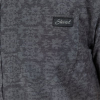 Close-up of a dark gray textured fabric garment with a chest pocket and a black embroidered 'Stewart' brand patch.