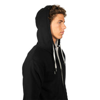 A man in profile wearing a black zip-up hoodie with white drawstrings, photographed against a solid white background.