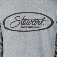 Close-up of a heather gray sweatshirt featuring a black oval graphic with the script word 'Stewart' and the text 'SURFBOARDS' underneath.