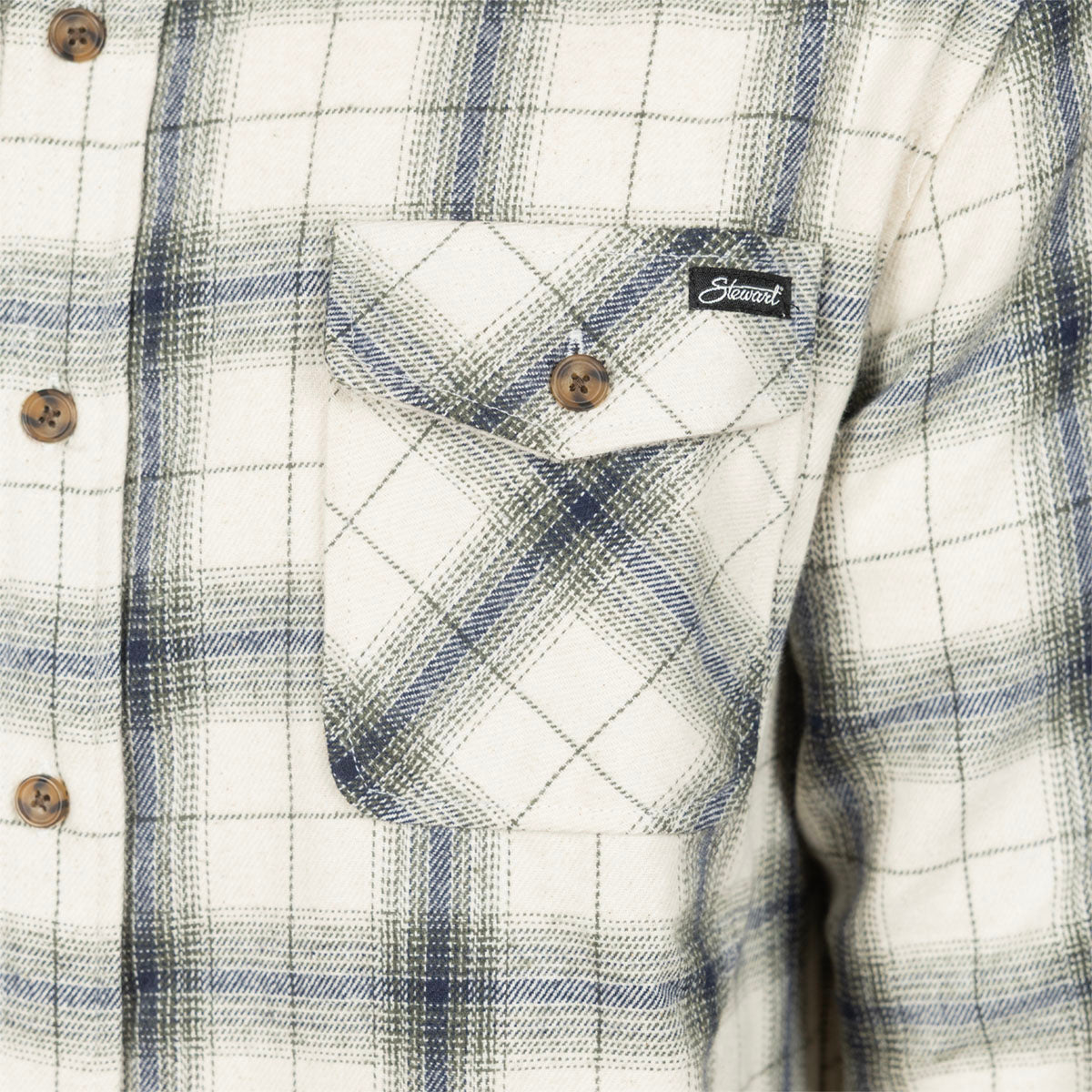 Close-up of a plaid button-up shirt with a chest pocket, featuring a white base with blue and gray plaid lines and a small black brand label on the pocket.