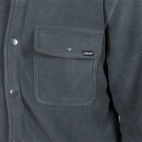 Close-up of a dark gray fleece jacket featuring a chest pocket with a flap, silver snap buttons, and a small black brand patch.