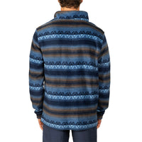 A man viewed from the back wearing a long-sleeve knit quarter-zip fleece with horizontal stripes in navy, blue, and brown, featuring geometric patterns.