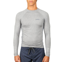 A man wearing a light gray long-sleeve compression shirt with a small logo on the left chest, paired with navy blue drawstring shorts, against a plain white background.