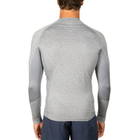 A man viewed from the back wearing a light gray long-sleeve athletic shirt with darker gray contrast panels on the sleeves, paired with navy pants, against a plain white background.