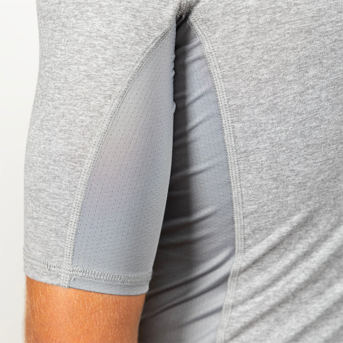 Close-up of a light gray athletic sleeve with a breathable mesh panel and a side slit showing the inner lining, worn by a model.